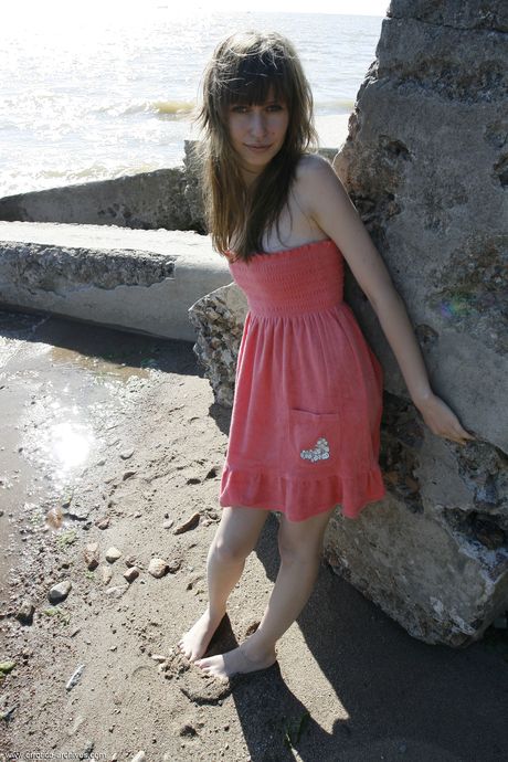 Engaging teen Lilly B gets naked on a beach with allure