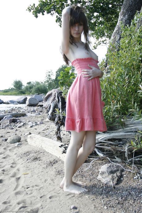 Engaging teen Lilly B gets naked on a beach with allure