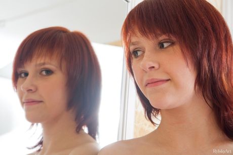 Young Redhead Anelie entfernt einen BH und ein Höschen, um nackt zu posieren
