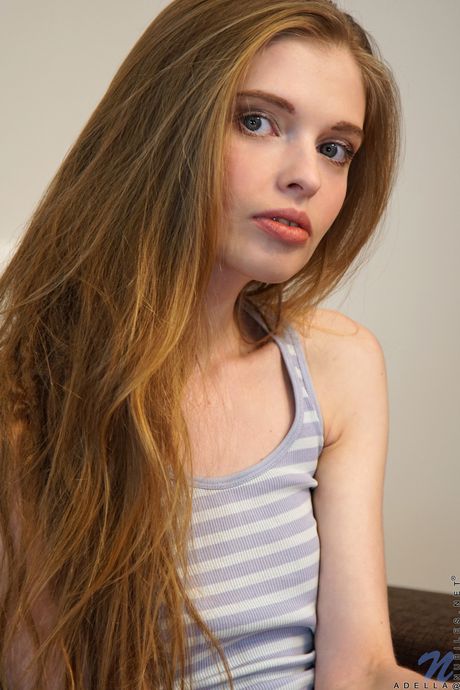 Skinny blonde Adella shows her small boobs and bald pussy in stockings