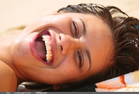 Solo girl with short hair and a great body poses nude on a rocky beach