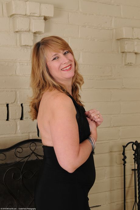 Redheaded mature lady Catrina Costa shows her big ass and tits