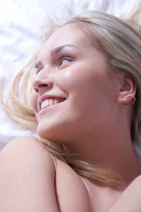 Sexy blonde Monique B poseert naakt in de keuken en op de tafel
