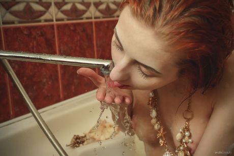 Smal Redhead Teen Olivia blir naken i badkaret
