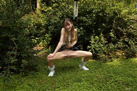 Petite teen Michelle Anthony pees on the lawn before inserting a toy