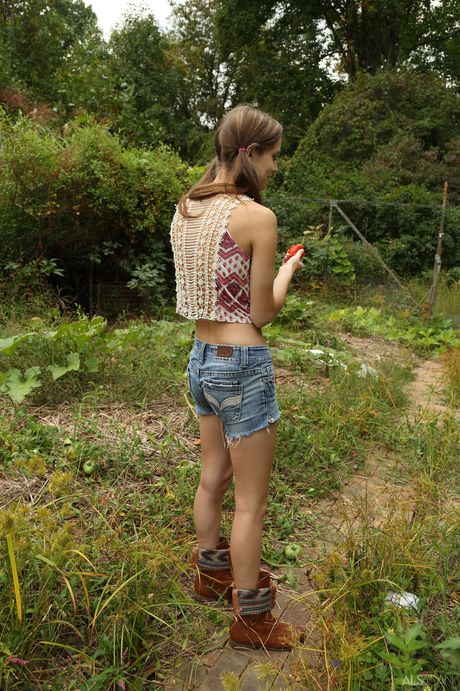 Charming teen Tali Dova strips and poses nude on a hay bale in the barn