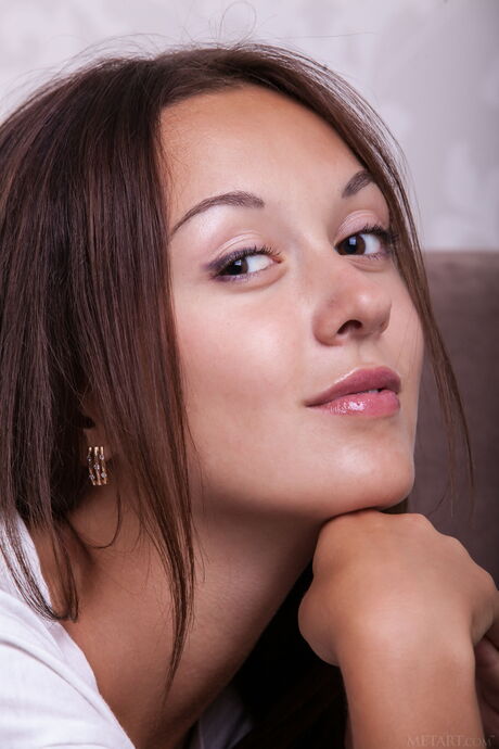 Gorgeous teen Veselin removes her shorts and T-shirt to pose nude on a couch