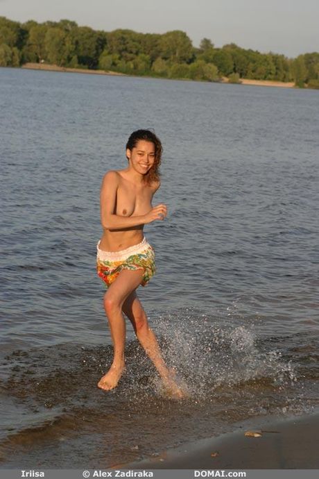 해변과 물속에서 알몸으로 포즈를 취하는 마른 십대 이리사
