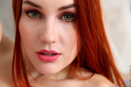 Skinny redhead Charlie Red masturbates with a vibrator on her bed