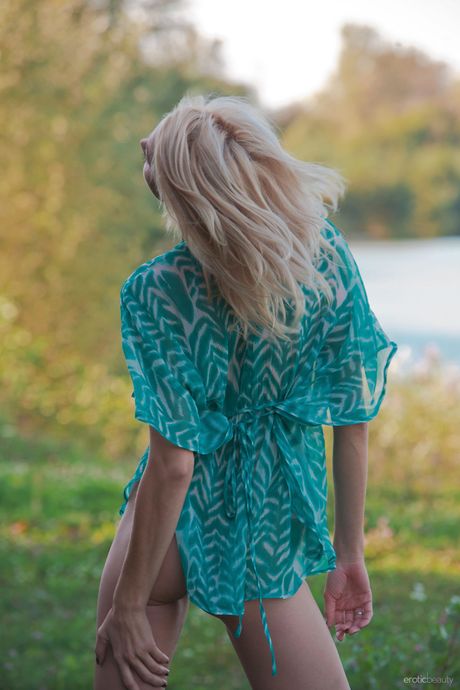 Blonde teen Lilly A goes nude on a blanket in a field by a river