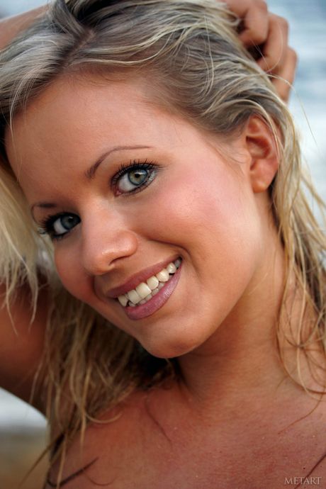 Skinny blonde Cody reveals her tiny tits and poses naked on the beach