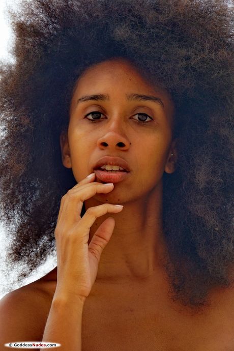 Ebony teen Isadora highlights her naked pussy while on a beach