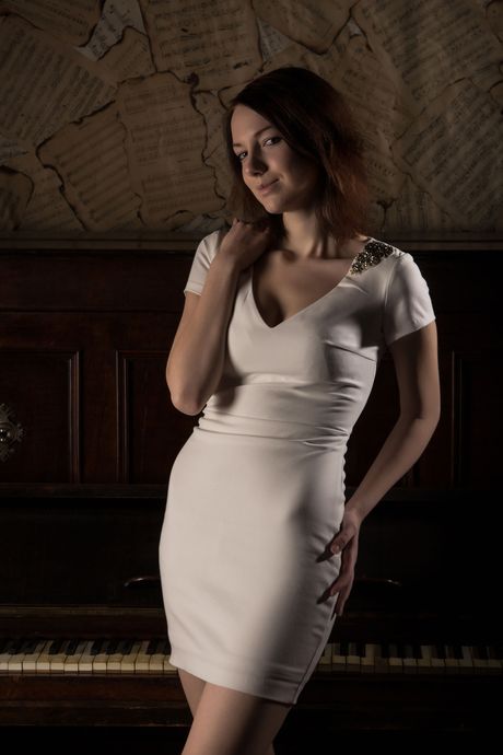 Natural redhead Lavana removes a dress and panties to pose nude