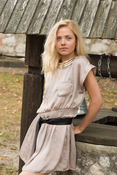 Sexy blonde Camelia removes her lingerie and poses nude by the well