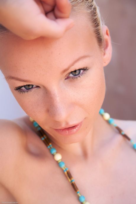 Gorgeous blonde teen Gwyneth models naked in high heels on a patio