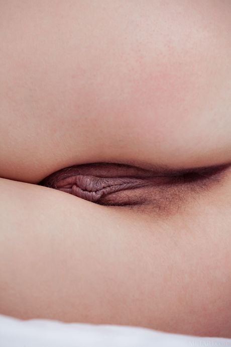 Bashful teen Iva removes her bikini to pose nude on a beach towel