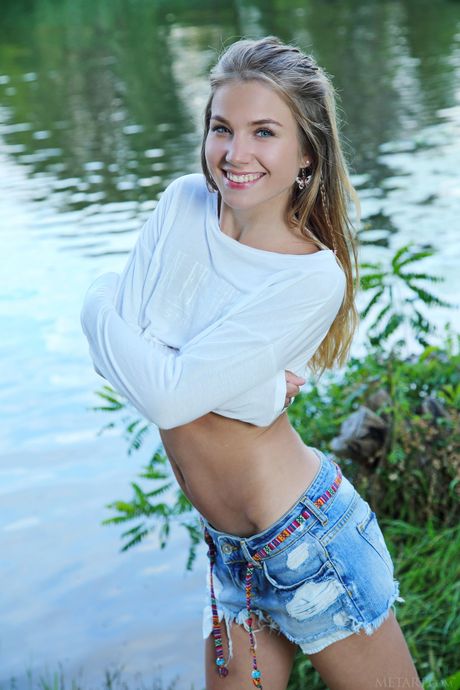 Tender teen Lola Krit removes her jean shorts and sweater to pose nude