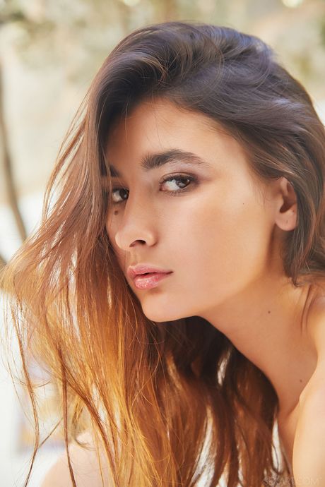 Brunette teen Bambi Joli fingers her pussy after getting naked on a bed