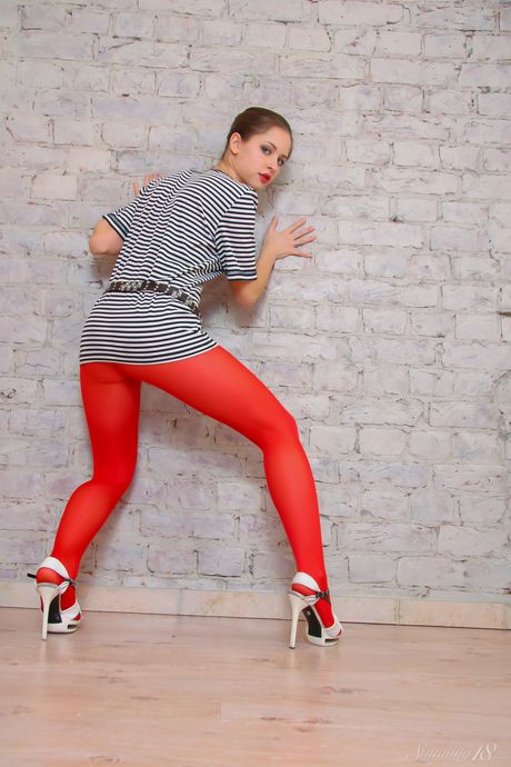 Beautiful teen Nelly J removes her pantyhose to get naked in heels