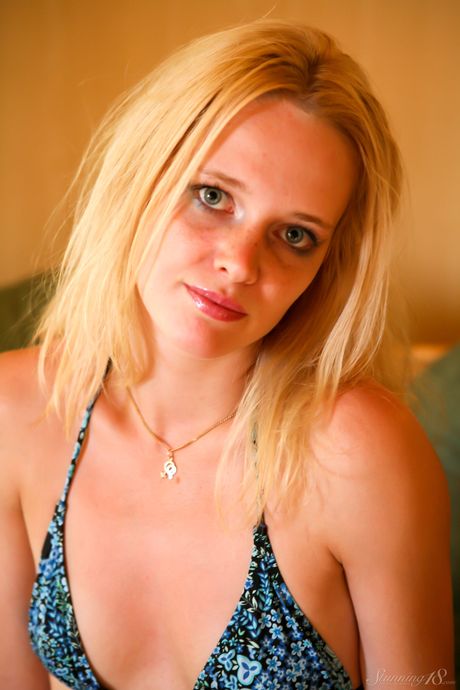 Blonde teen Petrina T removes a bikini to get naked on a patio