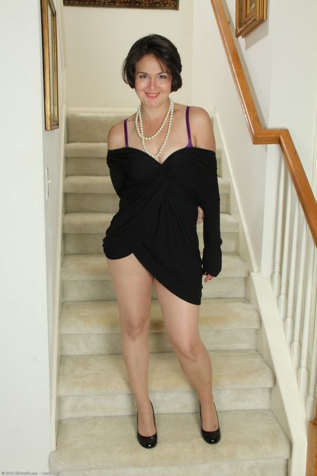 Mature woman Carlita Johnson removes satin lingerie to pose naked