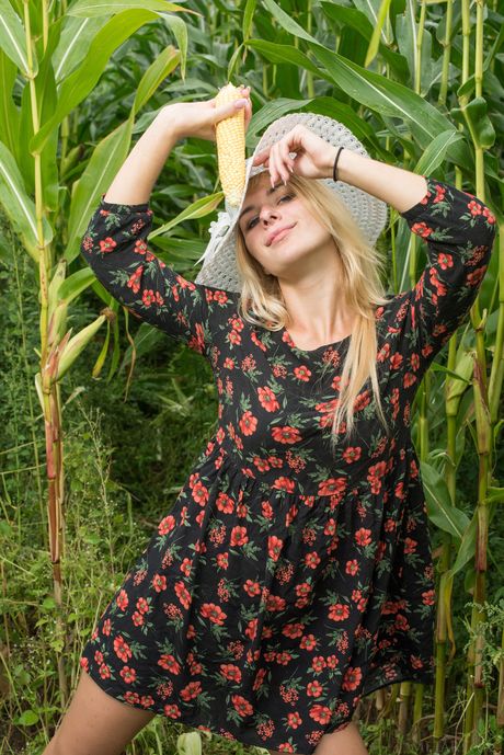 Blonde teen Yelena gets naked on a farm while holding a corn stalk