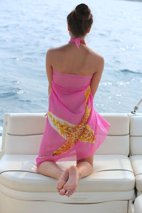 Slender teen Cira Nerri shows her small tits and bald pussy on a boat