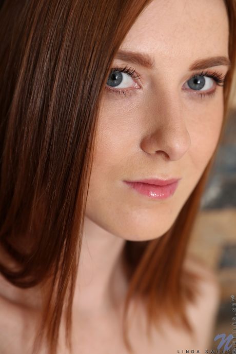 Redheaded teen Linda Sweet removes a red dress to model in the nude