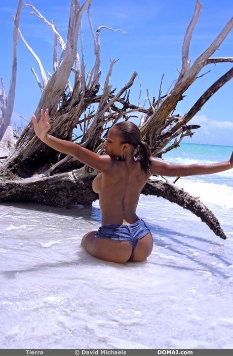 Stunning teen Tierra bares it all on a beach while oiling her body