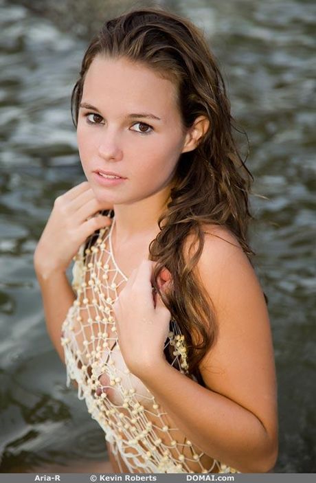 Lean teen Aria R gets wet while posing nude in a secluded outdoor location