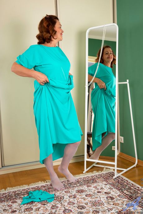 Redheaded mature Iris shows her big tits and spreads her pussy in stockings