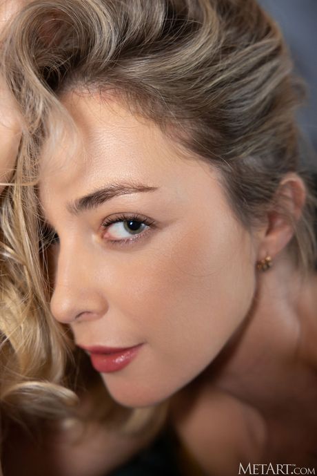 Emerald Ocean exhibits her big tits and shaved pussy as she poses on the couch