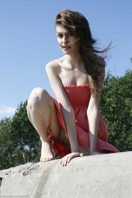 Young brunette Lilly B gets naked on a beach without shyness