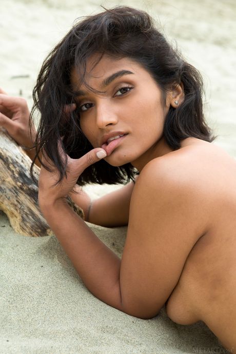 Stunning teen Angel Constance removes her bikini to pose nude on the beach