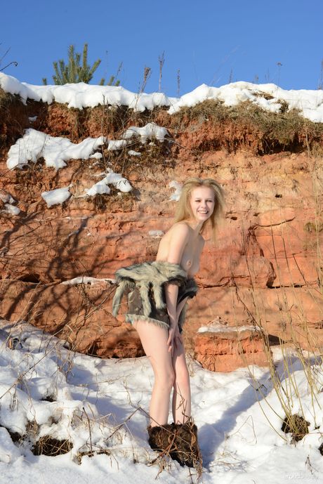 Sexy blonde Angelika D poses naked in the snow with her long hair flowing