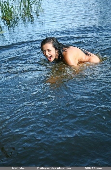 Brunette teen Martisha models totally naked in a shallow pool