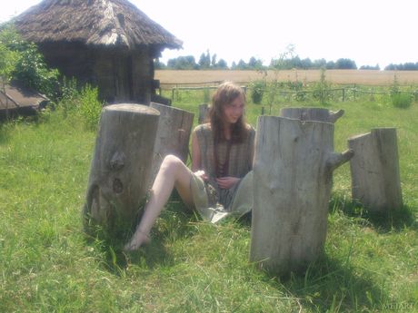 Lean Teen Katya B remsor nakna och poserar mitt i ett fält
