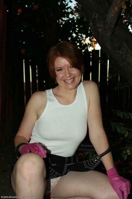 Mature redhead Ginny shows her big ass and spreads her pussy outdoors