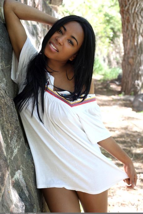 Black teen Tahela models totally naked in a secluded area of the forest