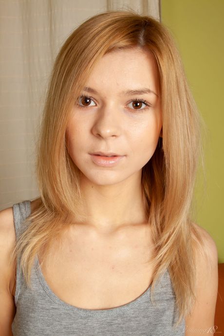 Niña apenas legal Paloma B se desnuda en un sofá con calcetines blancos
