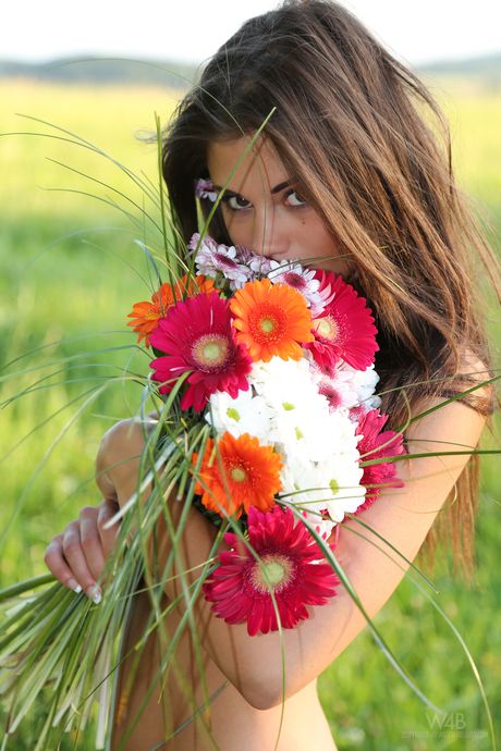 Cute teen Little Caprice models naked in a field of flowers