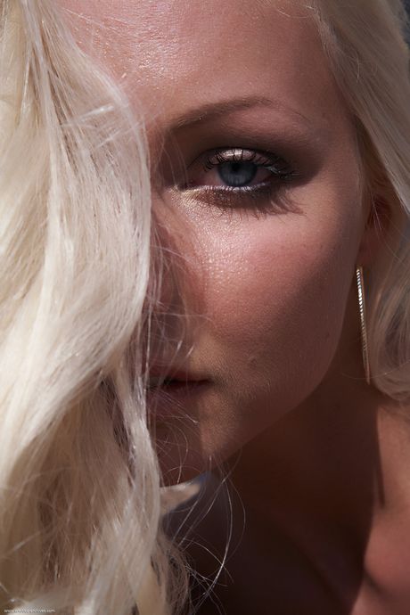 Blond tonåring Victoria blir naken i klackar på en balkong på ett sexigt sätt
