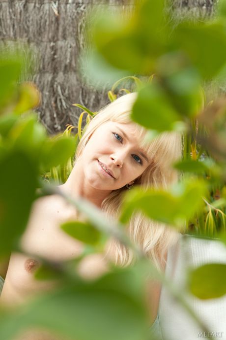 Blonde teen Tracy A removes her bikini and poses nude on the beach