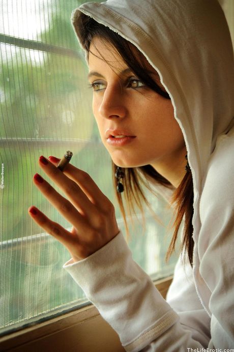 Lean teen Muriel smokes a cigar while modelling in the nude