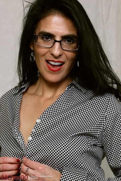Mature woman Veronica Perez removes her glasses and lingerie to pose naked