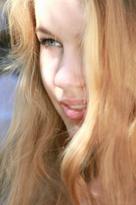 Blonde teen Genevieve Gandi gets naked on a rocky outcropping