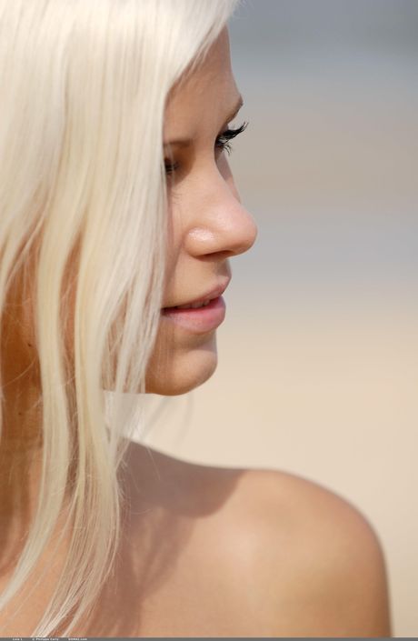 Rubio adolescente dido un modelos totalmente desnudos en un muelle en el agua
