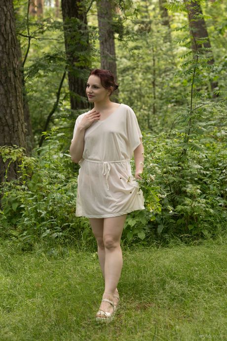 Skinny redhead Lisa Musa strips off her clothes near a pond and poses