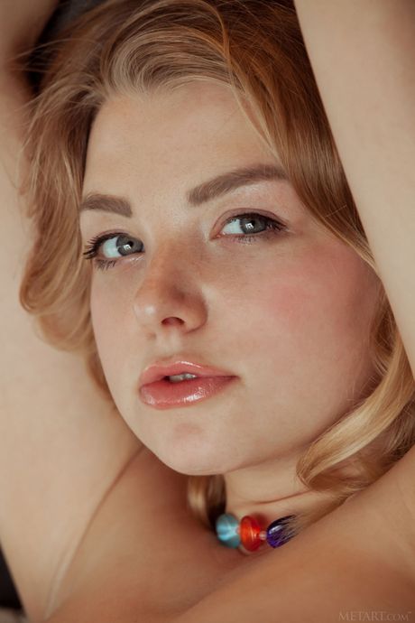 Sexy blonde Daniel Sea removes her clothes to show her big tits and bald pussy