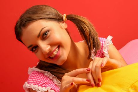 18-year-old blonde Dagny E gets completely naked on a bed during a solo shoot